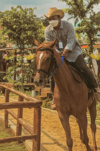 Side view of man riding horse