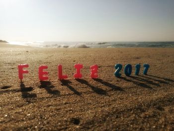 Close-up of text on sand at beach