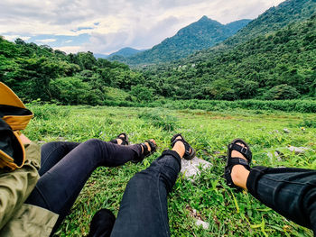 Low section of people relaxing on land against mountains