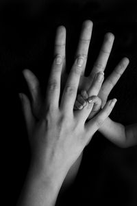 Close-up of hands of woman over black background