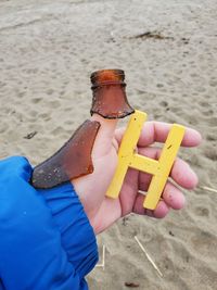 Close-up of woman holding umbrella on sand