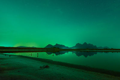 Scenic view of lake against sky at night