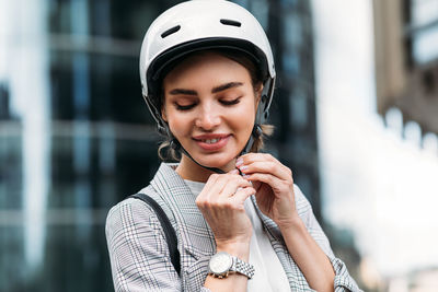 Cheerful caucasian woman wearing white cycling helmet preparing for ride	