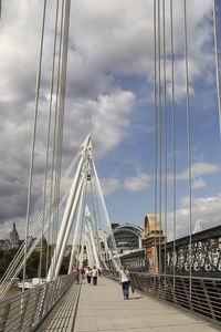 View of suspension bridge against cloudy sky