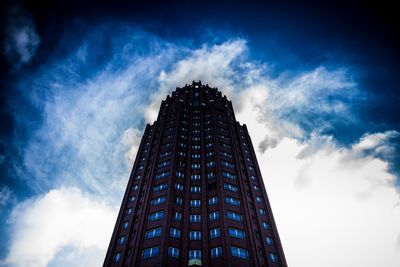 Low angle view of modern building against cloudy sky