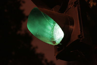 Low angle view of illuminated lighting equipment hanging at night