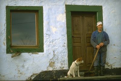 Man standing by window of house