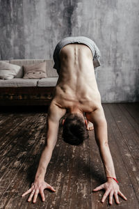 Full length of shirtless man lying on wood