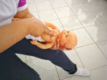 Low section of paramedic practicing on cpr dummy