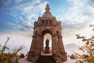 Low angle view of historical building against cloudy sky