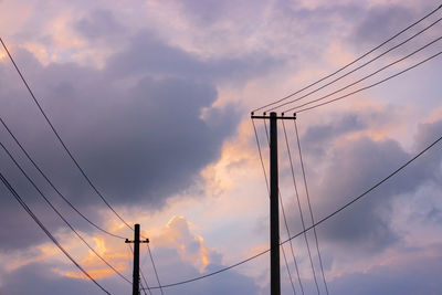 Low angle view of silhouette electricity pylon against sky during sunset