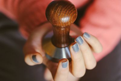 Close-up of human hand holding tamper