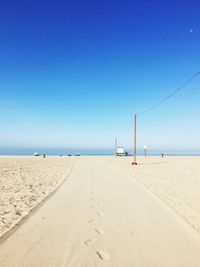 Scenic view of beach against clear blue sky