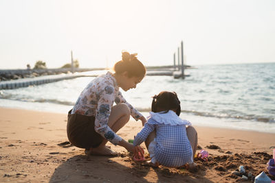 Rear view of woman sitting on beach