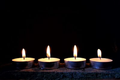 Close-up of candles burning at night