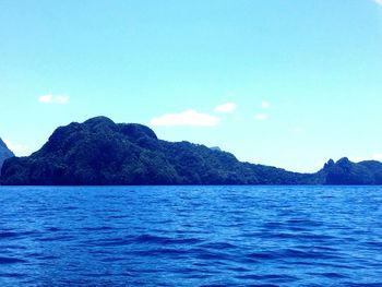 Scenic view of mountains against blue sky