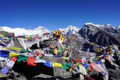 Multi colored prayer flags hanging on mountain against clear blue sky