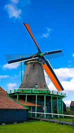 Low angle view of traditional windmill against cloudy sky