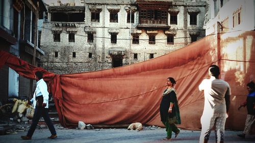 Rear view of people walking on building in city