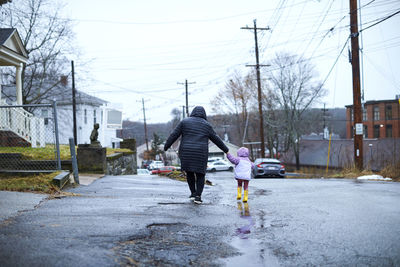 A mother and child playing outside on a rainy day.