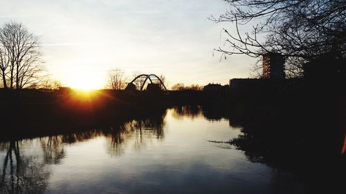 Scenic view of river against sky at sunset