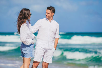 Portrait of smiling couple standing at beach