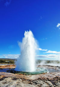 Water splashing against blue sky