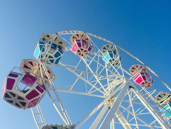 Low angle view of ferris wheel against clear blue sky