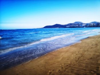 Scenic view of sea against clear blue sky