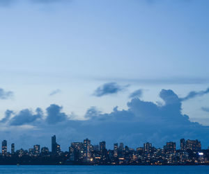 Sea by buildings against sky in city