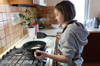 Side view of woman preparing food at home