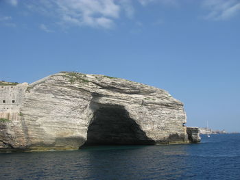 Rock formations by sea against sky