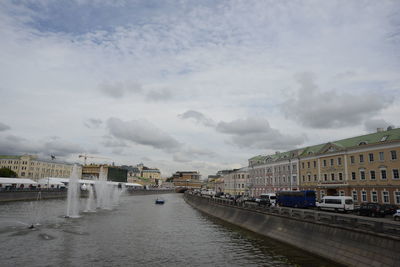 River amidst buildings in city against sky