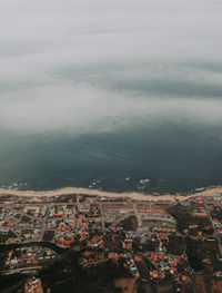 High angle view of townscape by sea against sky