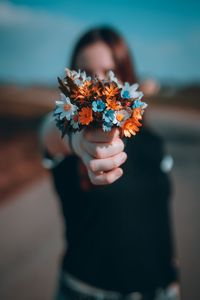 Close-up of woman holding flowering plant