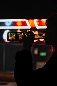 Close-up portrait of man using smart phone at night