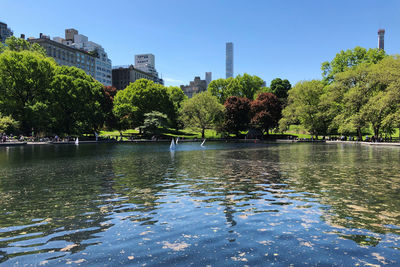 Scenic view of lake by buildings against clear sky