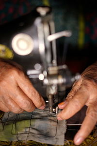 Cropped hand of person working on sewing machine