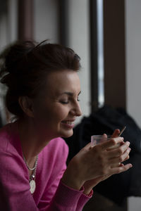 Side view of young woman using mobile phone