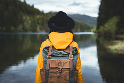 Rear view of man standing on boat in lake