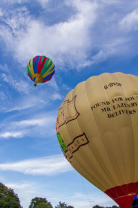 Low angle view of hot air balloons flying in sky