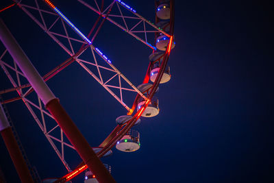 Low angle view of illuminated ferris wheel against sky at night