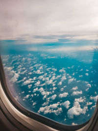 Aerial view of clouds seen through airplane window