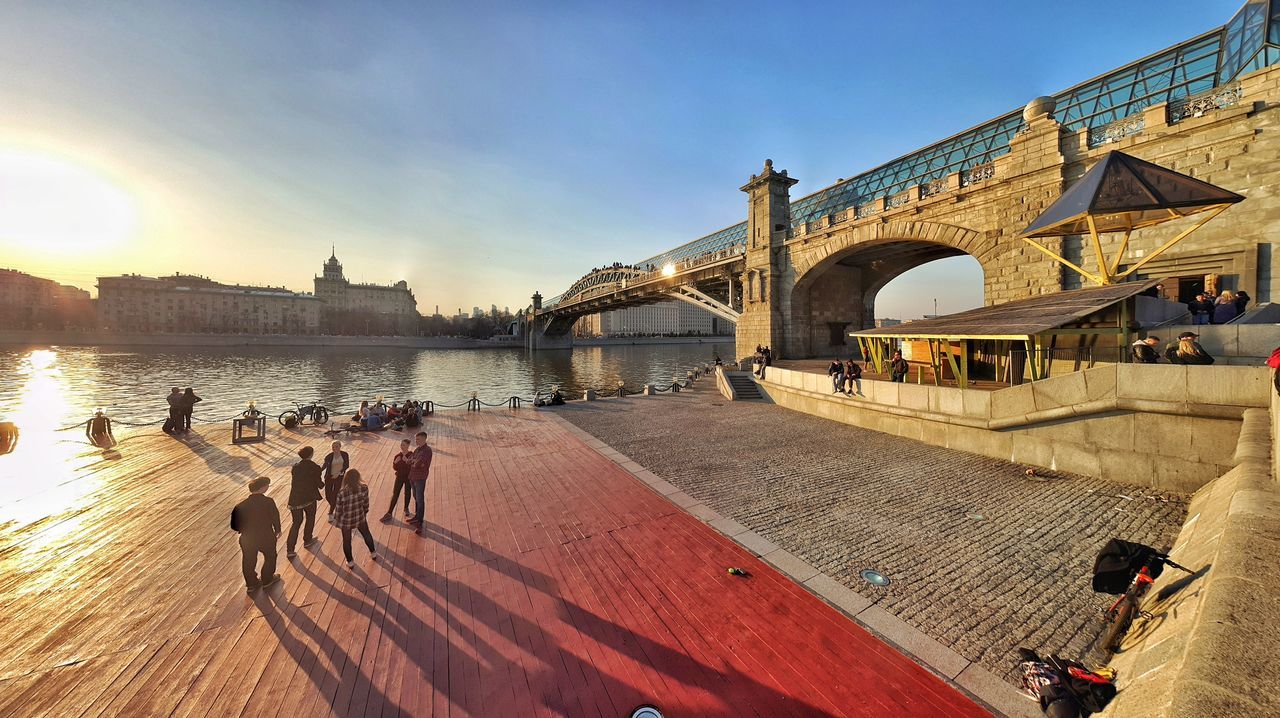 PEOPLE ON BRIDGE OVER RIVER