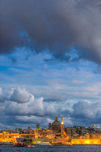 Buildings in city against cloudy sky