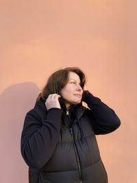 Young woman standing against sky during sunset