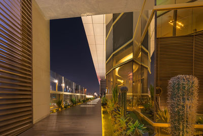 Illuminated street amidst buildings in city at night