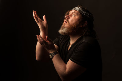 Side view of man looking away against black background