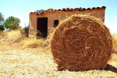 Hay bales on field against sky