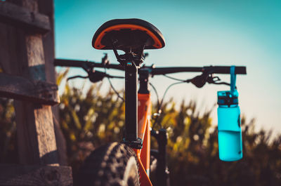 Close-up of bicycle on field against sky